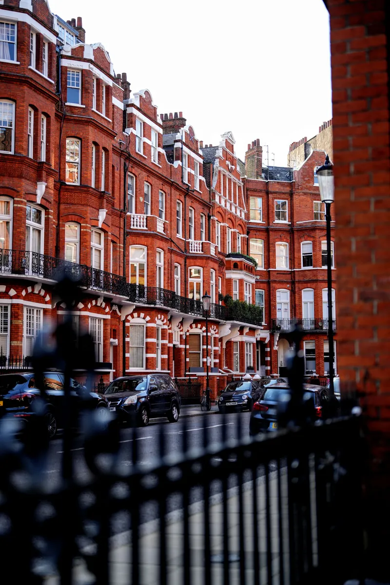 Red brick mansion flats behind black railings