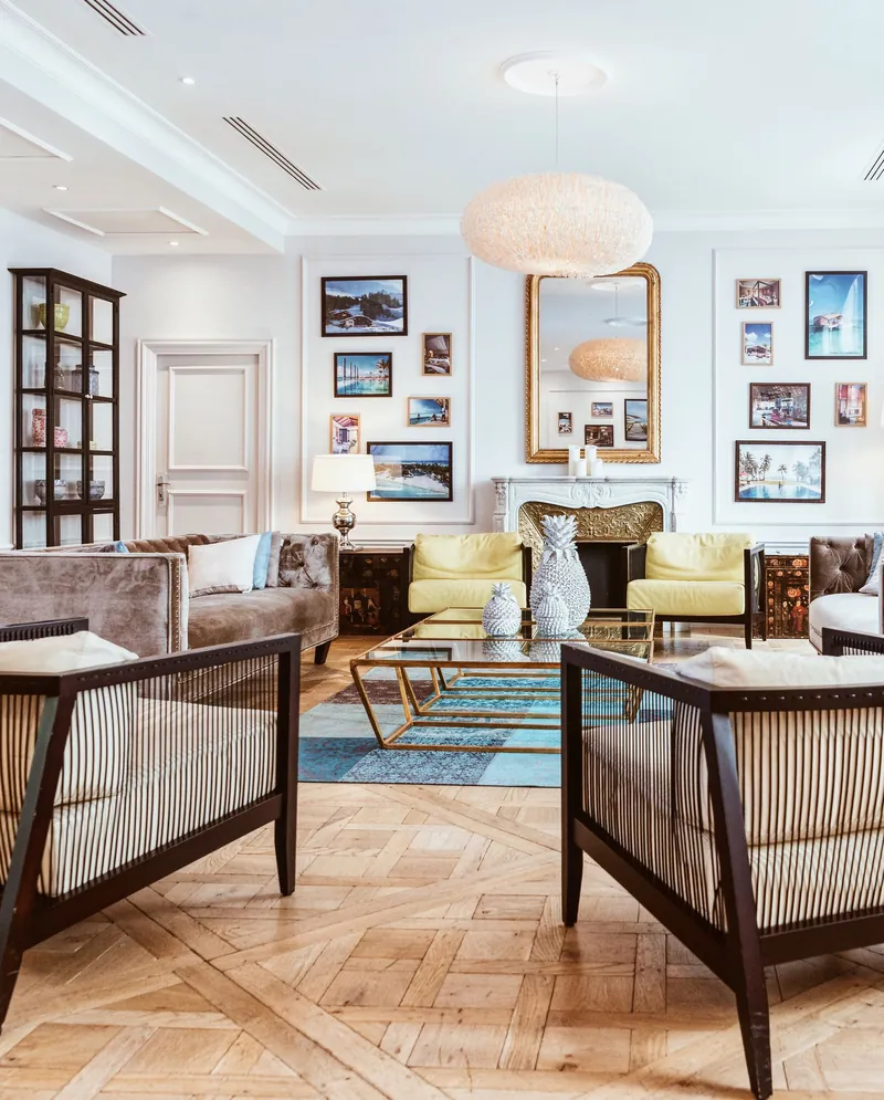 An open living room with wooden floors, books and art
