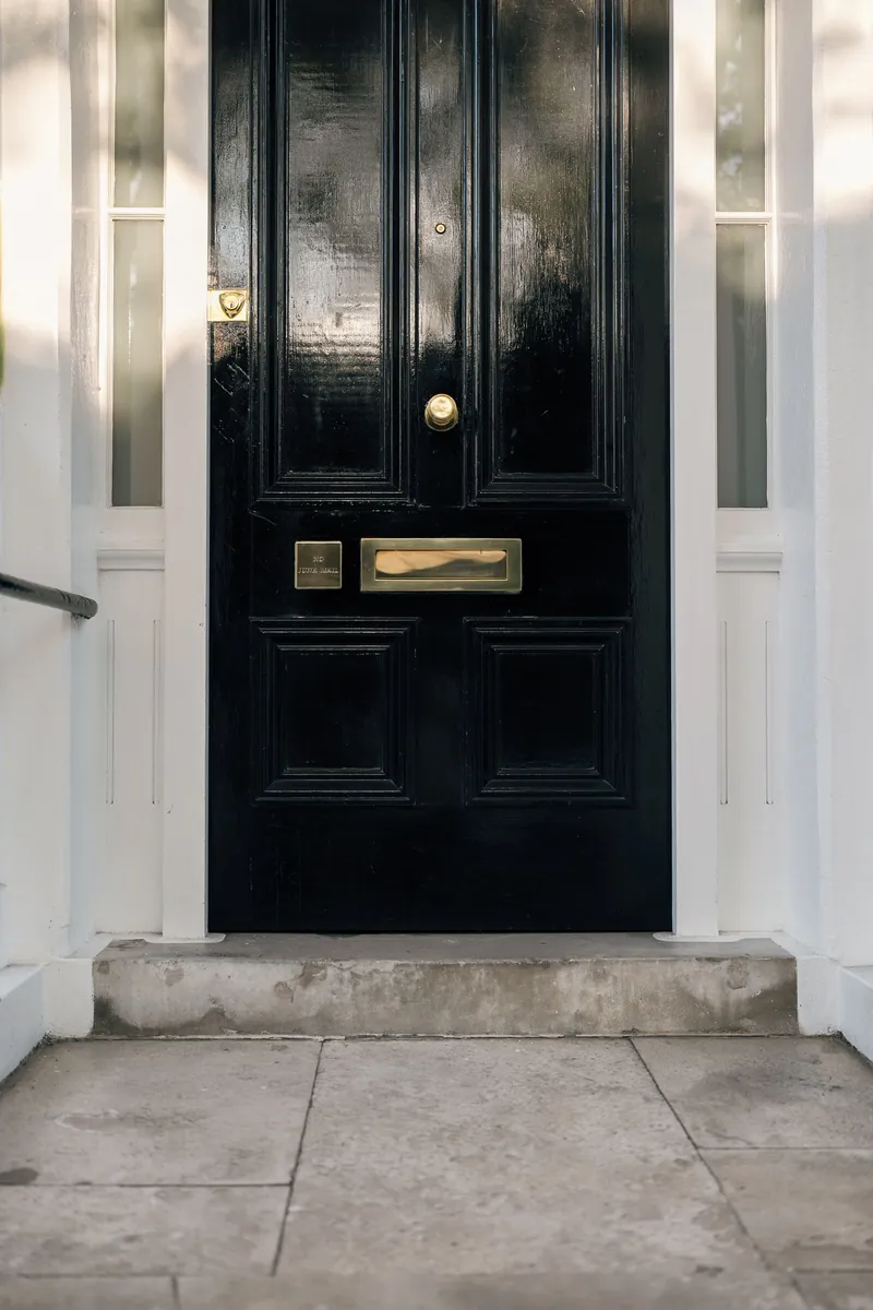A black front door with polished brass